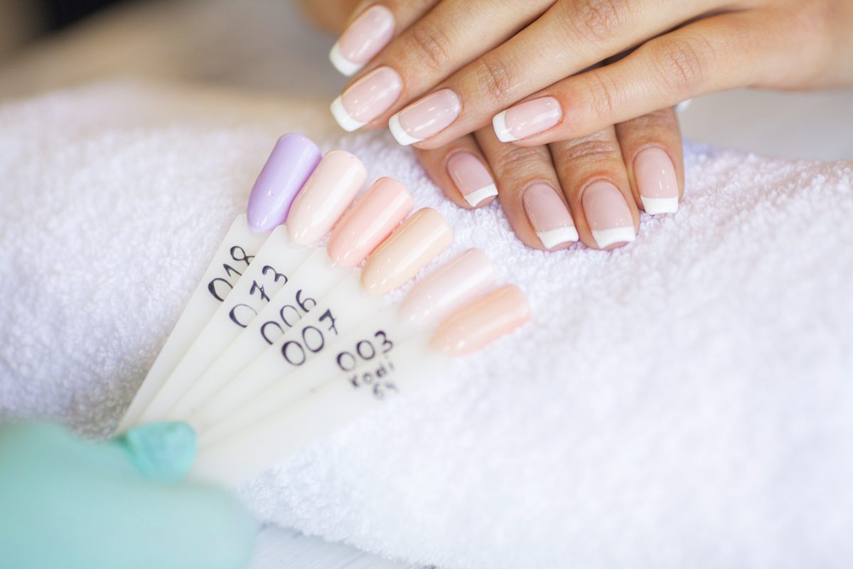 SPA manicure. French manicure at spa salon. Woman hands in a nail salon receiving a manicure procedure. 2025 nail color trends.