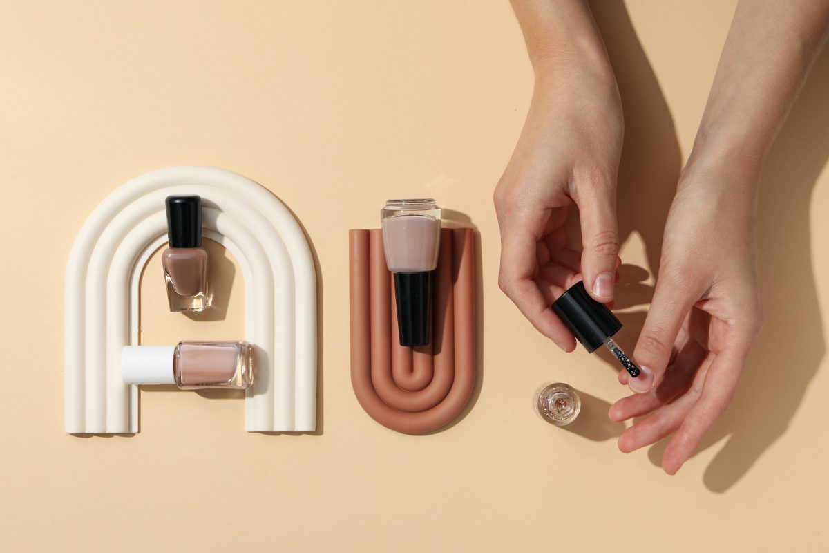 Nail polishes with decorations on a light background. 2025 nail color trends.