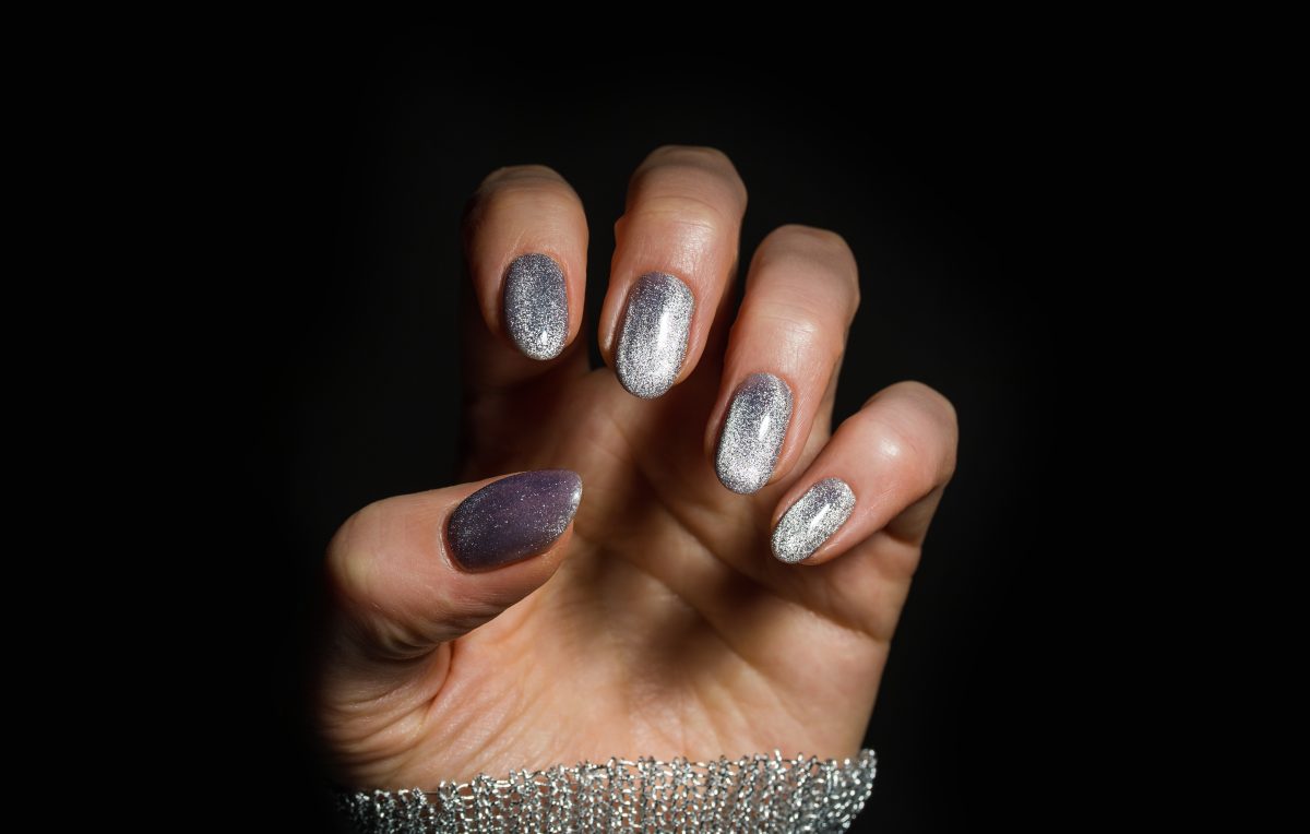 Nails Design. Hands With Bright Silver Christmas Manicure On Black Background. Close Up Of Female Hands. Art Nail.