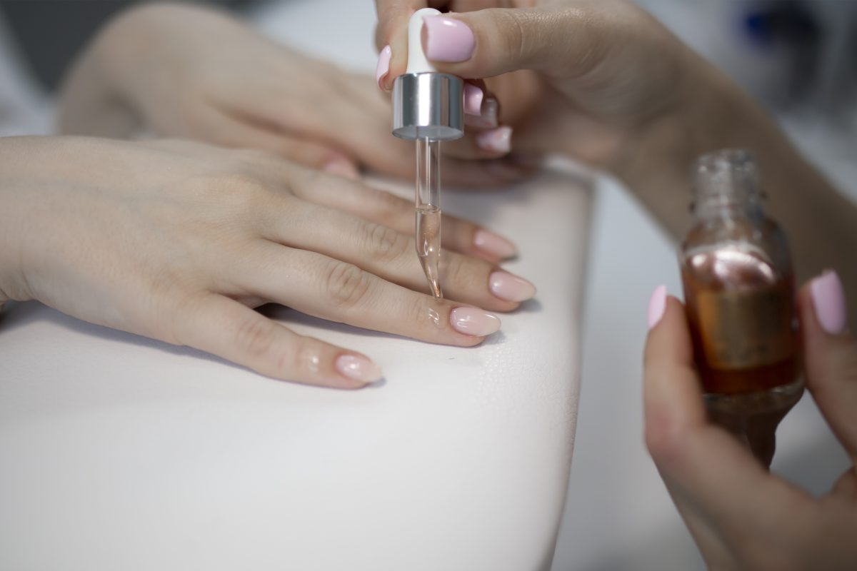 manicurist applying gel on the client's nail. protection cover