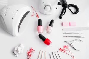 Tools of a manicure set on a white background. Ultraviolet lamp and manicure sander for manicure. top 10 must-have 2025 Nail Tech Tools for pros.