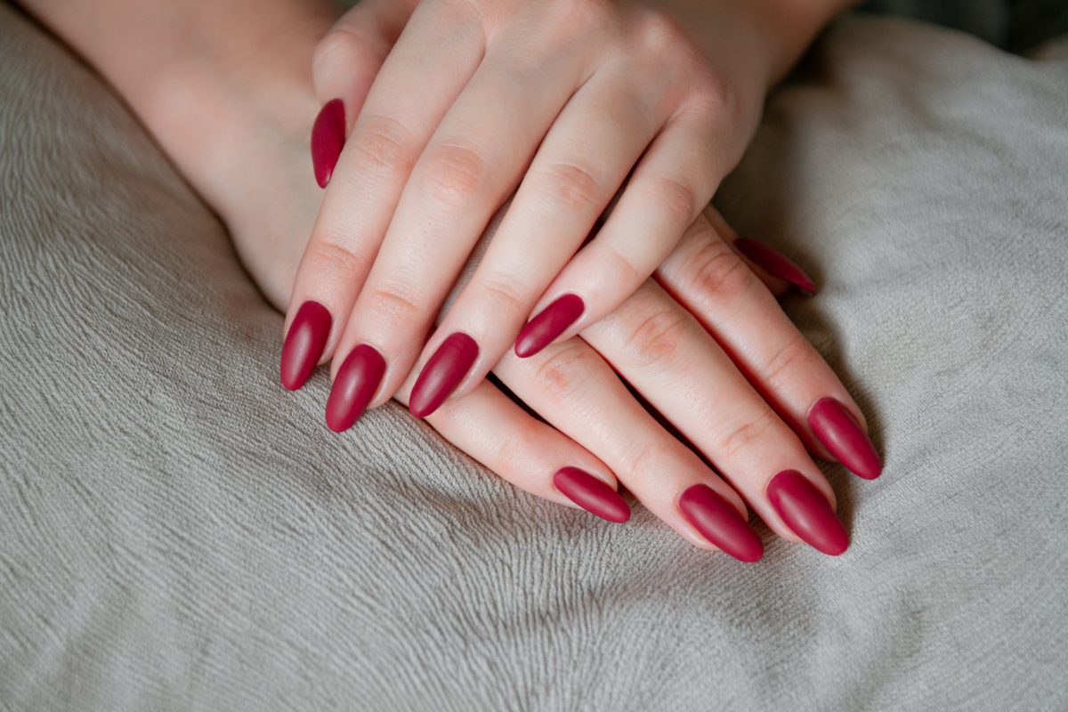 2025 Nail Color Trends. Model woman showing red shellac manicure on the long nails