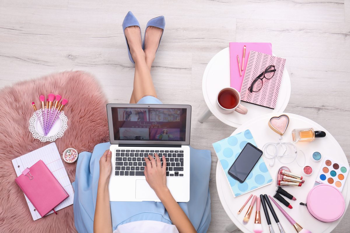 home-based nail business. Beauty blogger with laptop and cosmetics sitting on floor, top view