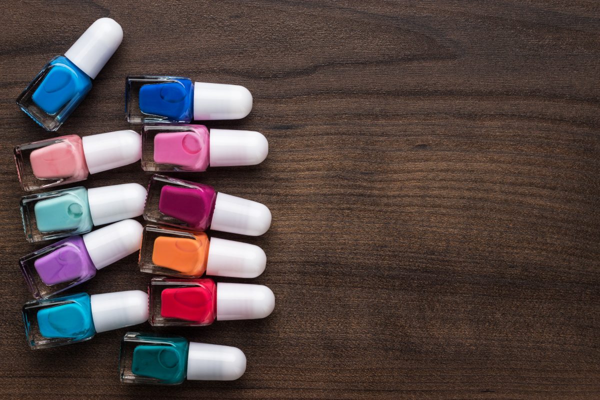 nail polish bottles of different colors on brown wooden table