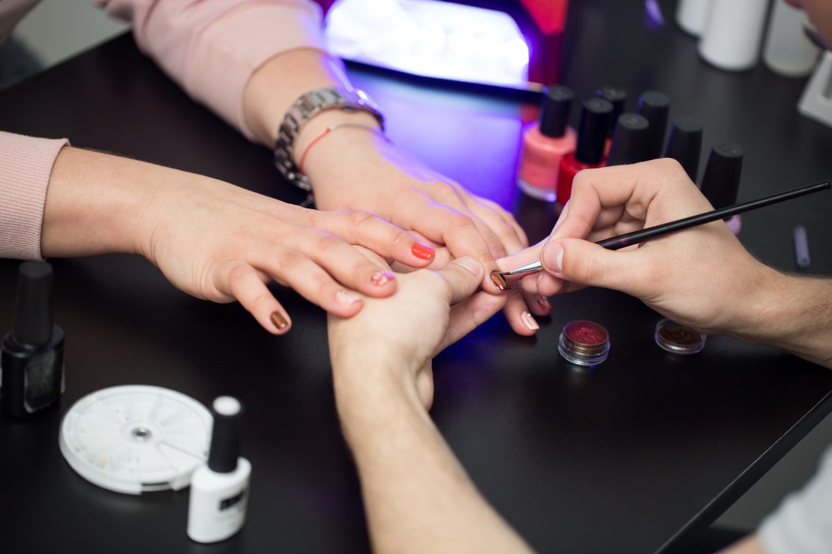 Closeup shot man making manicure to woman in beauty salon