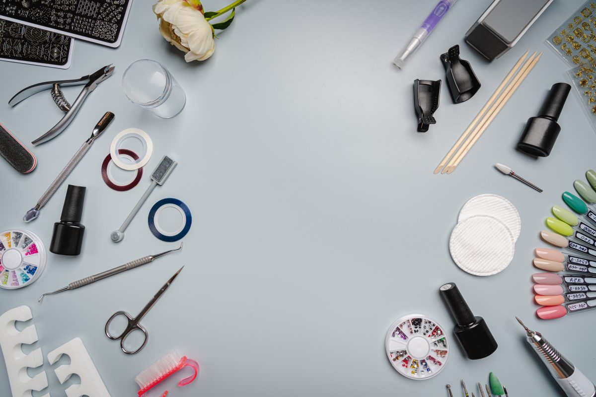 Set of manicure tools and accessories for manicure, nail polish and design on a blue background. Flat lay, top view with Copy space.