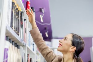 Smiling woman in beauty salon looking for beauty skin care retail products